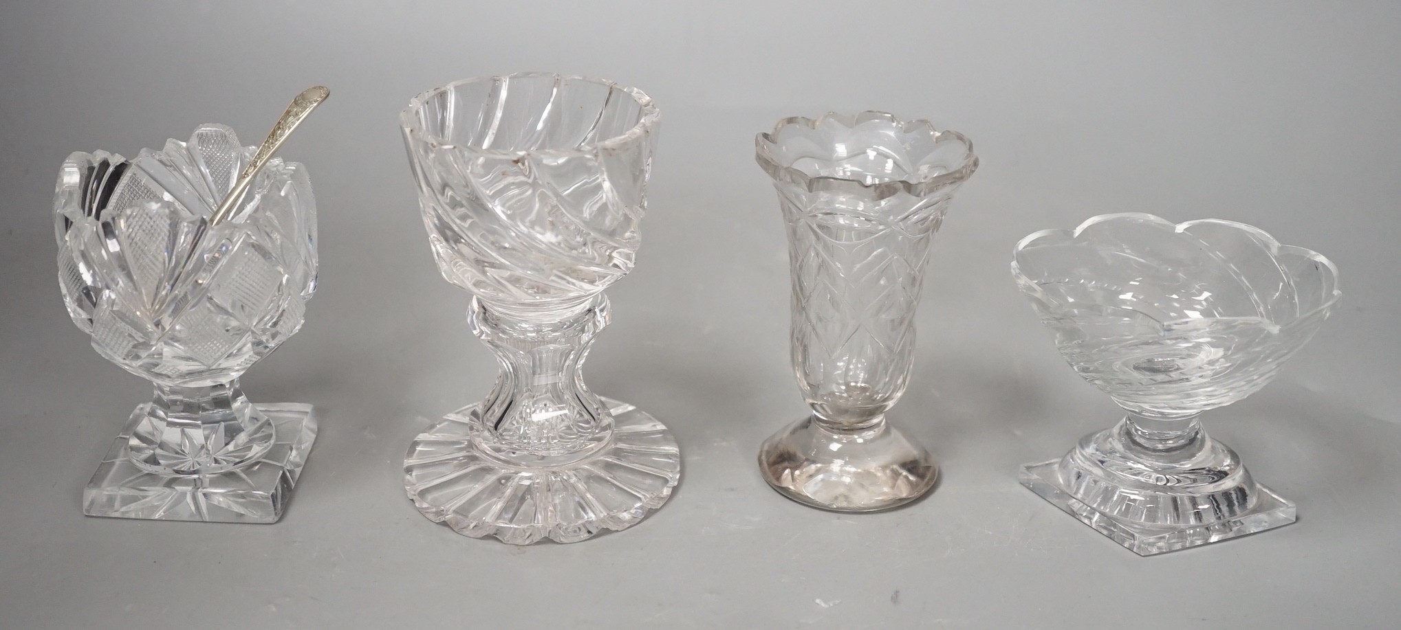 A set of twelve Victorian square base cut glass salts and four other 19th century clear glass salts.